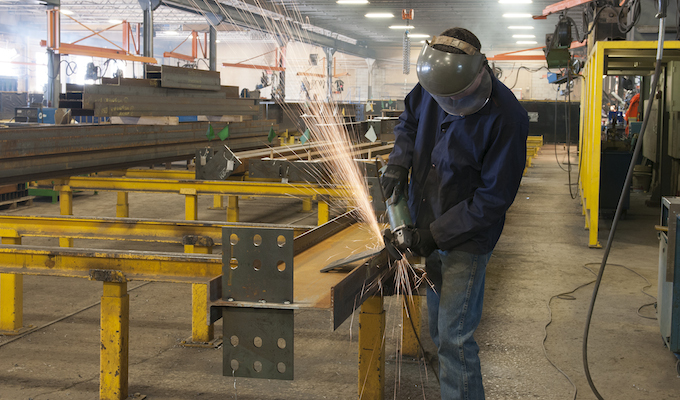 fabricator grinding a beam